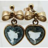 A pair of 9ct gold earrings set with a heart shaped aquamarines and a bow to the stud