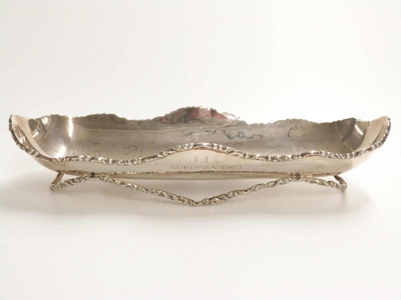 Mexican white metal long dish raised on cast bar stand, marks rubbed but sterling Mexico visible,