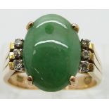 A 14ct gold ring set with a jadeite cabochon and six diamonds, size O