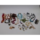 A collection of costume jewellery including brooches, beaded necklaces, silver and agate necklace