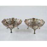 A pair of George V hallmarked silver pierced bonbon dishes, raised on three feet, Birmingham 1915