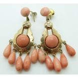 A pair of 9ct gold earrings set with five pear drop coral beads and two coral cabochons to each