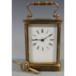 Early twentieth century brass carriage clock in corniche style case, with white enamel dial and