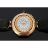 A 14ct gold ladies wristwatch converted from a pocket watch, with gilt decorated white enamel