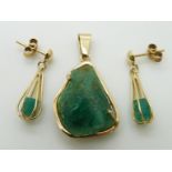 An 18ct gold pendant set with a rough emerald, with matching earrings