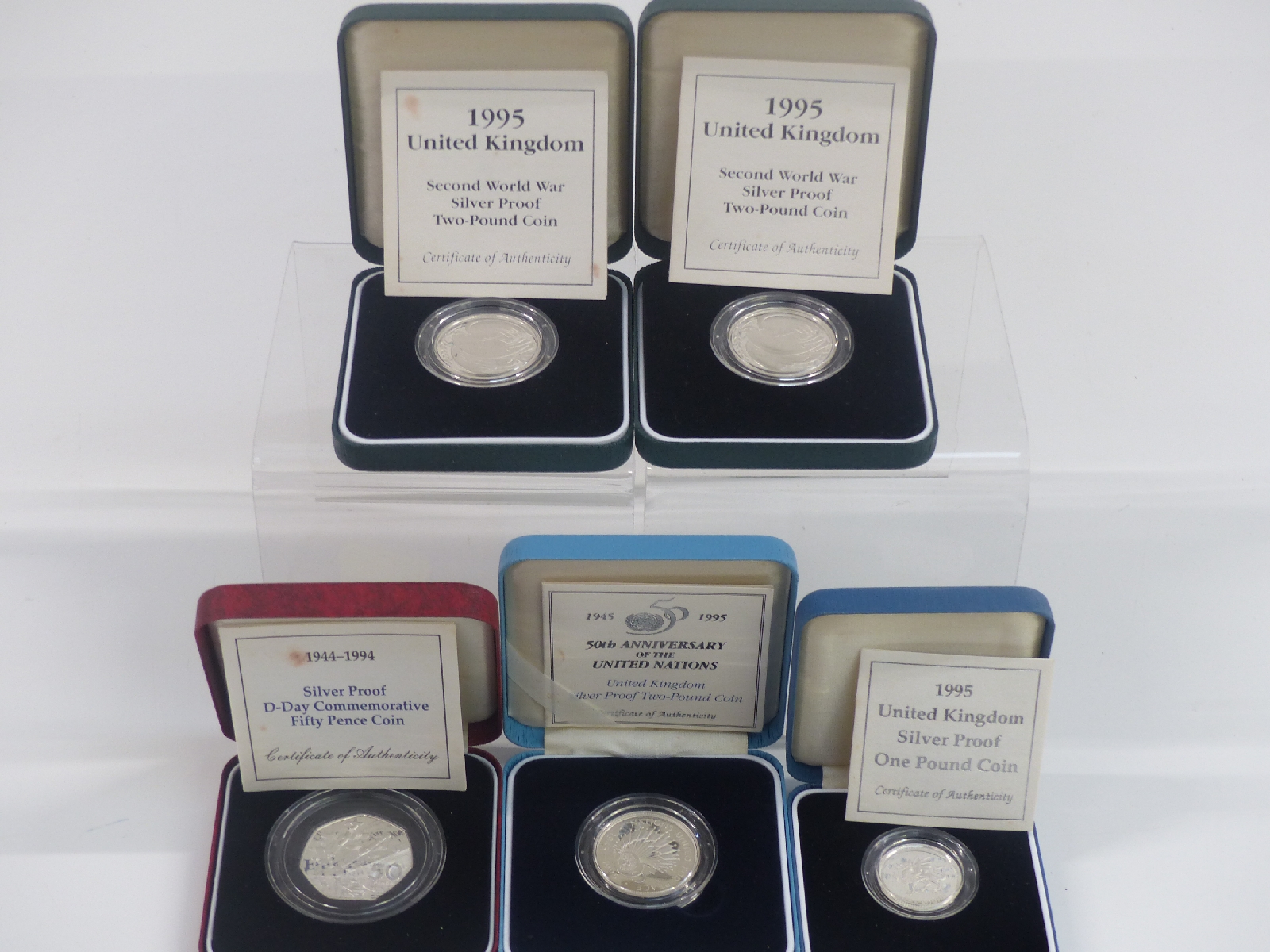 Five cased silver proof commemorative UK coins to include two pounds, one pound and fifty pence