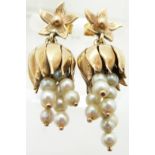 A pair of gold earrings set with pearls on drop sections