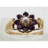 A 14ct gold ring set with a pearl surrounded by amethysts, size M/N