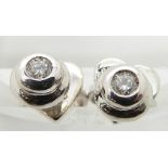 A pair of 18ct white gold studs set with a diamond to each