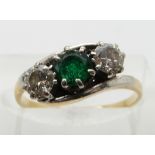 An 18ct gold ring set with an emerald and two diamonds, each approximately 0.3ct, in a platinum