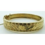 A 14ct gold bangle with engraved decoration, 32.4g