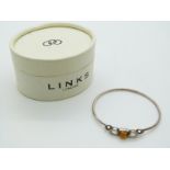 Links of London silver bracelet with letter F charm and a silver bangle set with pressed amber and