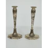 A pair of continental white metal candlesticks with octagonal bases, indistinct possibly German