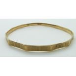 A 9ct gold flapper bangle with engine turned decoration,15.2g