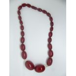 A cherry amber necklace made up of graduated oval beads, 66g