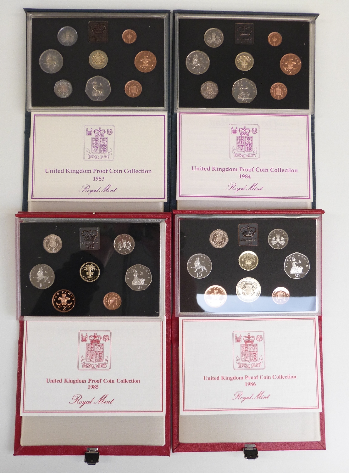 Four Royal Mint deluxe cased UK proof coin sets 1983, 1984, 1985 and 1986