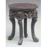 A Chinese carved hardwood stand in the form of a Padauk table, height 25 x diameter 21 cm