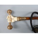 Victorian parasol, the handle an 18ct gold plated and ivory fist holding a bar, with yellow metal