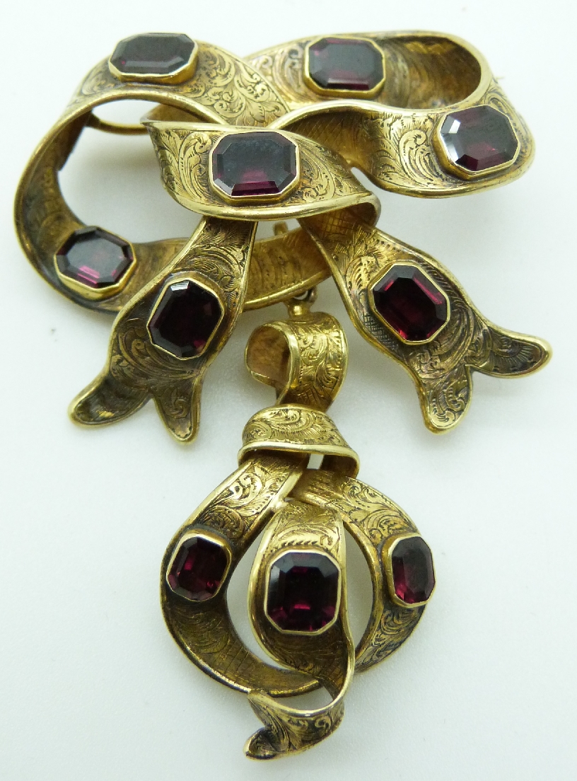 Victorian gold bow brooch set with foiled emerald cut garnets and chased detail in original fitted