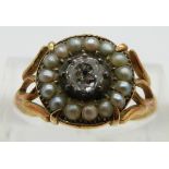 An early Victorian ring set with an old cut diamond of approximately 0.35ct surrounded by seed