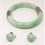 A jadeite bangle with white metal fittings and jadeite earrings with silver fittings