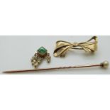 A 9ct gold bow brooch, an emerald and seed pearl charm and a stick pin set with a pearl