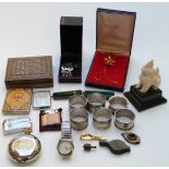 A collection of items including a Vizagapatam box, a carved figure, napkin rings, a Ronson lighter