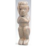 An 18thC / 19thC African carved wood tribal figure in seated position with clasped hands, 15cm