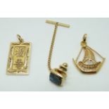 A 14ct gold Chinese pendant (4g) and a yellow metal boat pendant (3.2g)