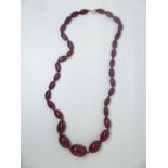 A cherry amber necklace made up of graduated oval beads, 30g