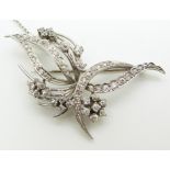 A platinum brooch in a stylised floral/foliate design set with diamonds