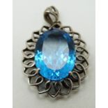 A 9ct white gold pendant in the form of a stylized flower set with blue topaz