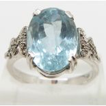 An 18ct white gold ring set with an oval mixed cut aquamarine and diamonds to the shoulders, size