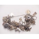 A vintage hallmarked silver and white metal charm bracelet including approximately 40 charms