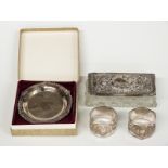 A boxed feature hallmarked silver dish, pair of hallmarked silver napkin rings and a silver lidded