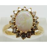 An 18ct gold ring set with an opal cabochon and diamonds, size N