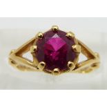 An 18ct gold ring set with a round cut synthetic ruby, size H