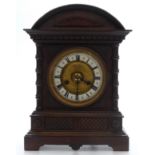 C1900 Carved Oak and Mahogany cased mantel clock, the white Roman chapter ring with central