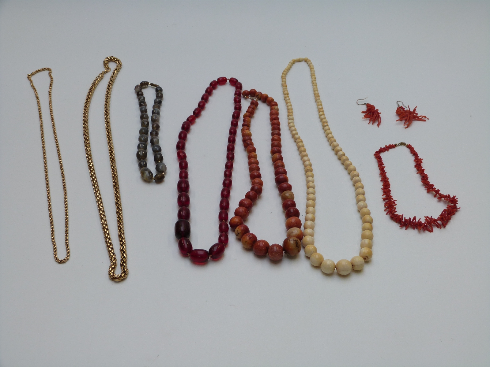 A collection of necklaces including early 20thC ivory, coral, cherry amber, gold plated, agate etc