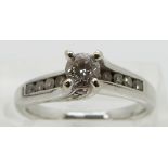 An 18ct white gold ring set with a round cut diamond of approximately 0.25ct with diamond