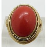 A 9ct gold ring set with a coral cabochon, size K