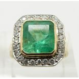 An 18ct gold ring set with an emerald cut emerald approximately 3.3ct surround by diamonds, size N