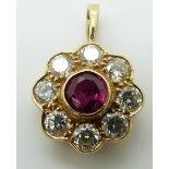 An 18ct gold pendant set with a round cut ruby of approximately 0.7ct surrounded by eight diamonds