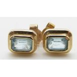 A pair of 9ct gold earrings set with an emerald cut blue topaz