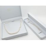 A single strand of pearls with a silver clasp and a pearl bracelet with alternating gold spheres