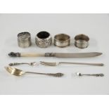 Three hallmarked silver napkin rings, hallmarked silver pickle fork and a part gilt spoon marked