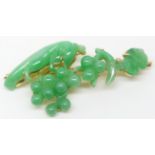 An 18ct gold brooch set with a carved jadeite section depicting animals, fruit and leaves by Zhou