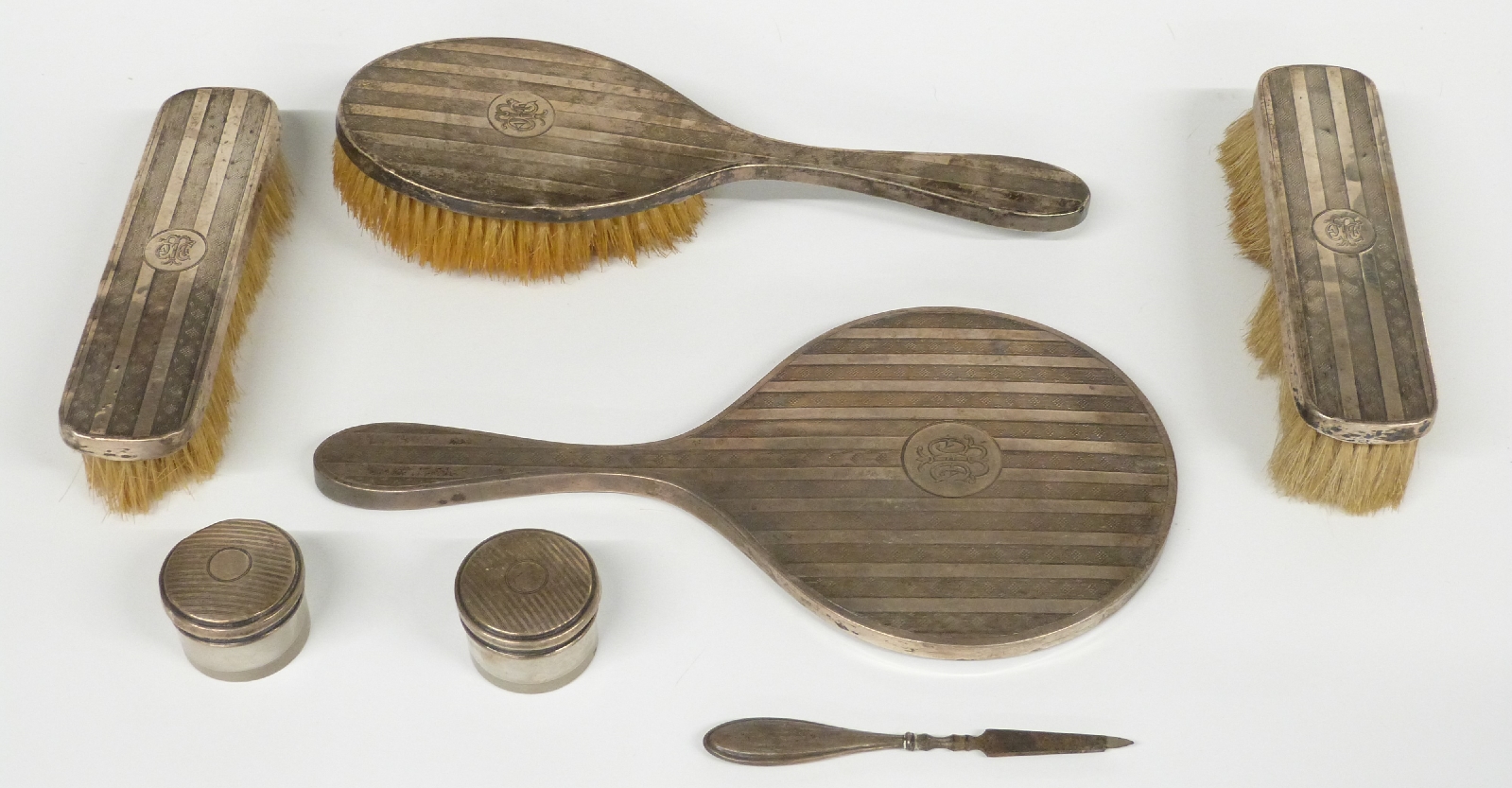 Four piece hallmarked silver dressing table set comprising hand mirror and three brushes, two silver