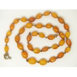 A Baltic amber necklace made up of graduated oval beads, largest bead 1cm x 0.8cm, 13g