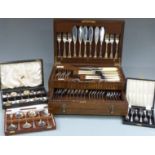 An oak cased six place setting canteen of cutlery together with three further boxed sets of cutlery